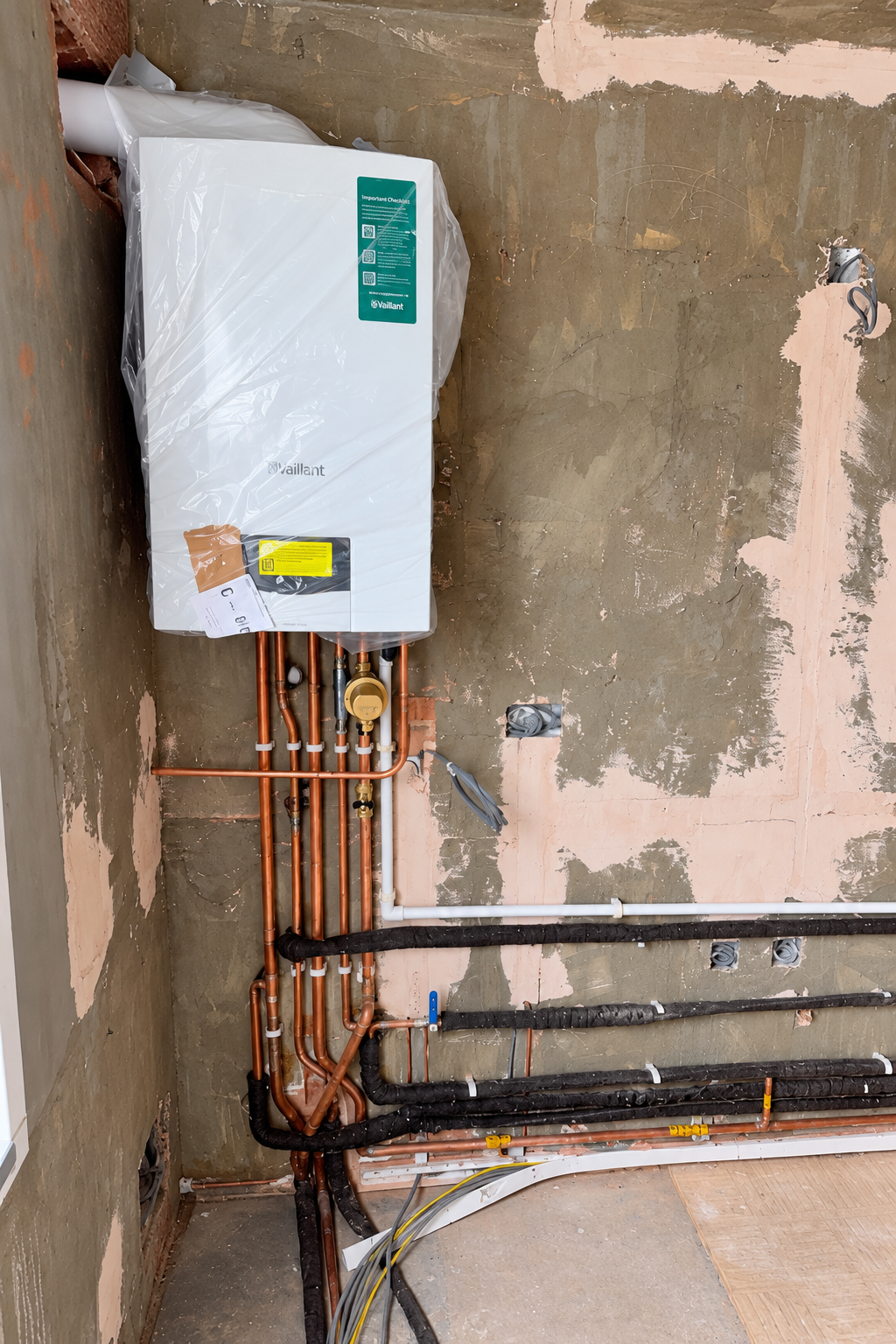 Wall-mounted boiler and copper pipework during installation